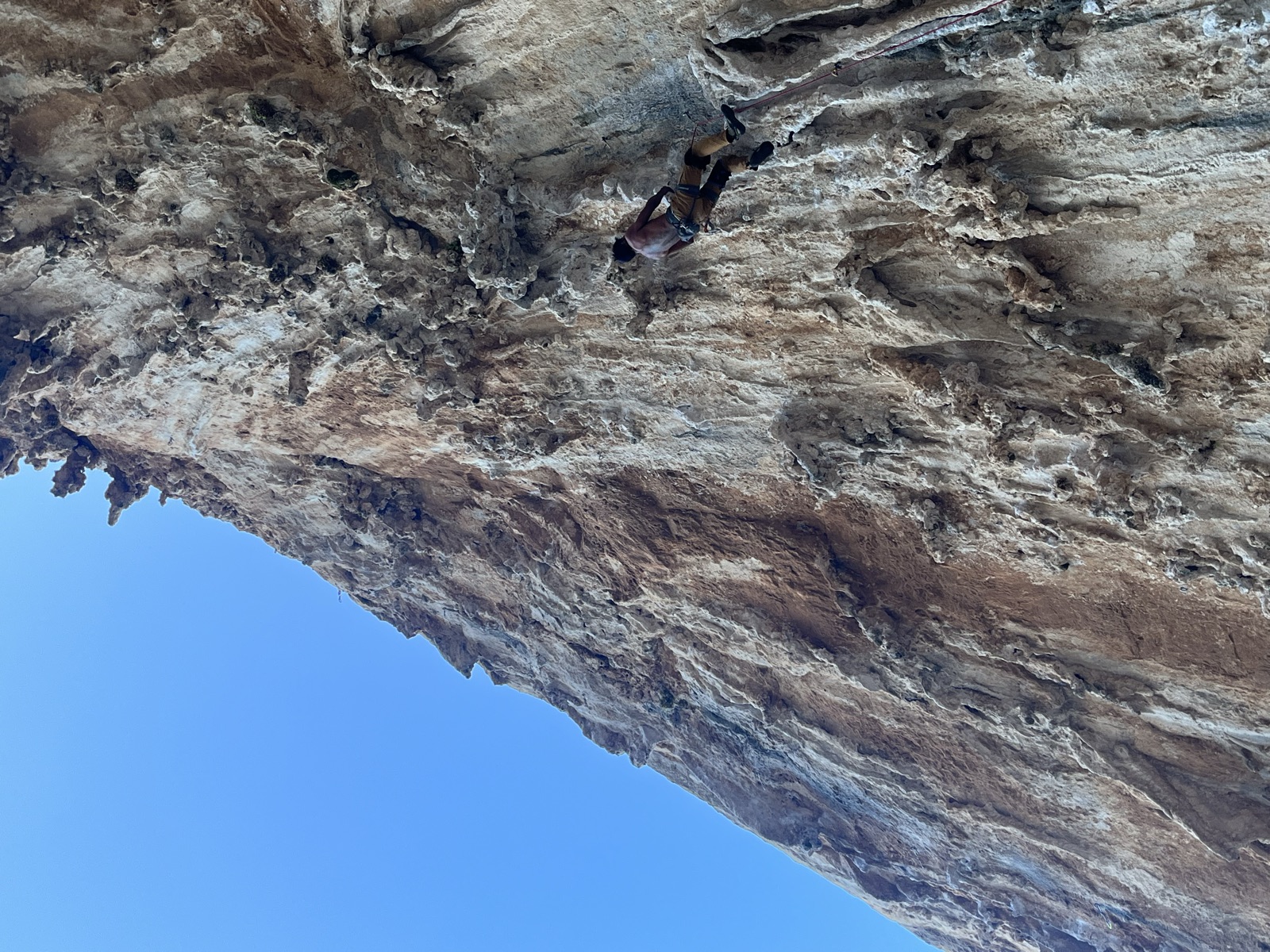 Paused on the tufa wall of DNA, red rope hanging down